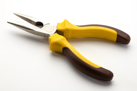 Pliers with yellow and brown rubber grips on a white background. The tool features pointed tips and is commonly used for gripping and bending materials.の写真素材
