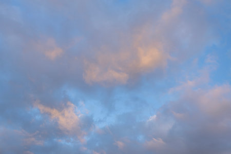 Abstract sky background with soft clouds in shades of blue and pink. The texture creates a calming...