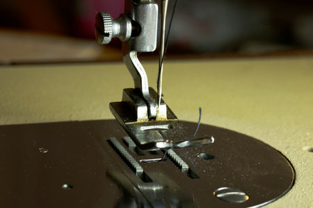 Old sewing machine, needle and thread.