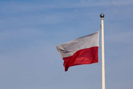 Polish flag flying against the background of the blue skyの写真素材