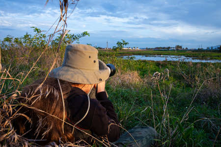 photographer taking pictures of wildlife with a telephoto lens
