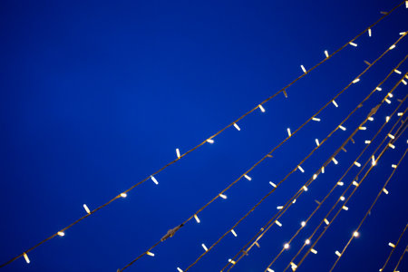 Festive light garlands against the background of the evening skyの写真素材