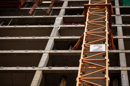 Yellow construction crane attached to the wall of an office building under construction