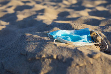 Worn Covid masks on the beachの写真素材