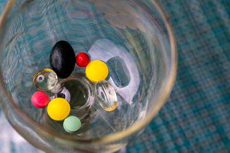 Lots of pills in the glass for various illnessesの写真素材