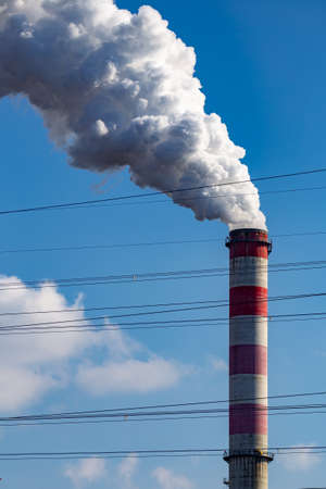 A close-up of the smoking chimneys of a coal-fired power plant. Made in a sunny day, deep blue skies