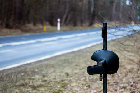 A roadside cross with a motorcycle helmet commemorating the tragic death of a motorcyclist. Made on a cloudy day, soft, soft light.の写真素材