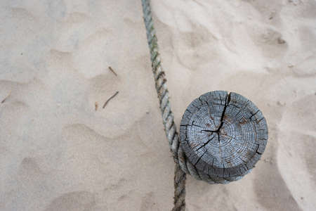 A wooden post with stretched ropes separating the hiking trail from the protected area. Photo taken in good lighting conditions on a cloudy dayの写真素材