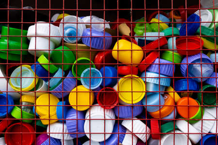Lot of PET bottle caps in recycling bin. Soft light, made on a cloudy day.の写真素材