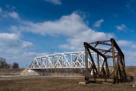 Rusty spans of the old railway bridge have been dismantled. Perspective photo taken on a sunny day.