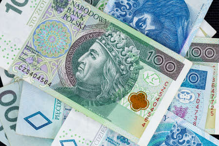 Polish banknotes of PLN 100 and PLN 50 randmply composed. Photo taken under soft artificial lightの写真素材
