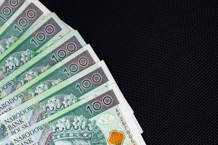 Polish banknotes of PLN 100 on a black background. Photo taken under soft artificial lightの写真素材