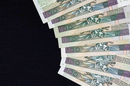 Polish banknotes of PLN 100 on a black background. Photo taken under soft artificial lightの写真素材