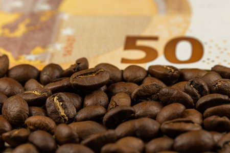 Roasted coffee beans together with 50 euro bill. High price of coffee. Pictute taken in good artificial light.の写真素材