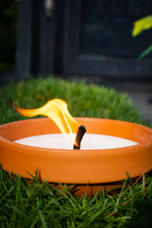 Side view of the burning graveyard candle. Photo taken in soft daylight