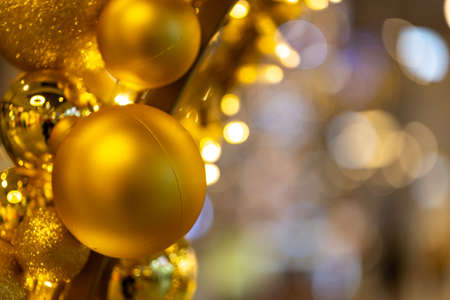 Golden Christmas tree balls on the Christmas tree. Photo taken under artificial, soft light.の写真素材