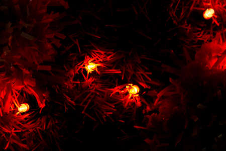 Close up of colorful lights on a Christmas tree. Photo taken at night. Lamps woven into the tree branchesの写真素材