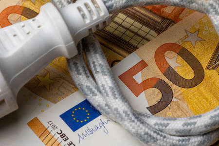 Electric cable with socket on the background of 50 Euro bill. Rise of electricity price in Europe....