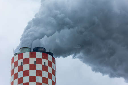 Dense clouds of smoke coming out of the chimney of a coal-fired power plant. Picture taken on a cloudy day, uniform and soft light.の写真素材