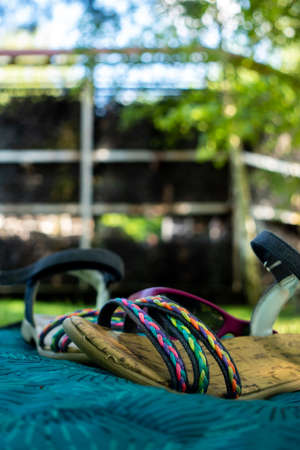Colorful children's sandals stacked on a blanket in a city park. Picture taken in the shade under soft natural light.の写真素材