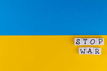 The sentence "Stop War" composed of letters on the background of Ukrainian flag. Photo taken under artificial, soft lightの写真素材