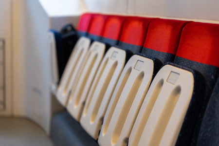 Empty interior of a commuter train during a pandemic. A view of a series of chairs along the...