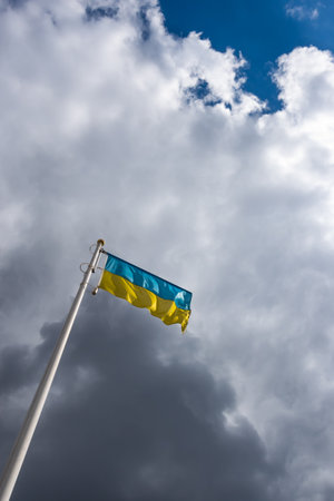 Ukrainian banner wave on the background of cloudy, dramatic sky. Picture taken in the day, sky full of clouds.の写真素材