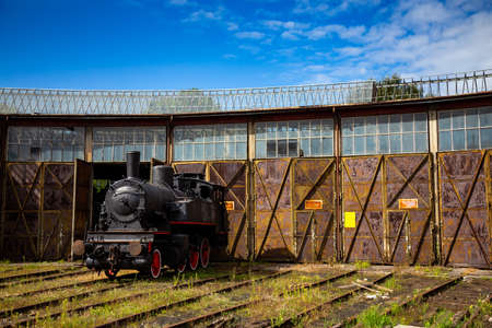 A steam locomotive standing outside of historic locomotive shed. The shot was taken in natural...