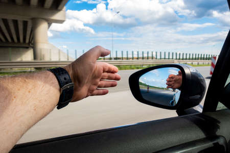 Relaxing car driving with hand outside the vehicle. Photo taken while driving on the highway.