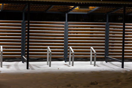 Empty shed with bicycle racks in a city park in winter. Difficulties in traveling by bike in winter.の写真素材