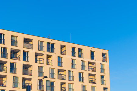 Facade with balconies in an apartment block. Multi-family housing, the object against the blue sky.