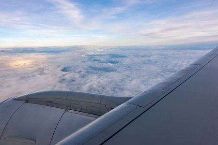 The engine and part of the wing of a passenger plane seen from the window during flight. Shot taken during a daytime flyby.の写真素材
