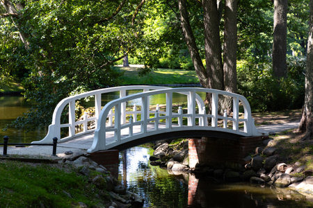 A little romantic bridge in a city park made of wood, painted in white. Park in natural light, on a...