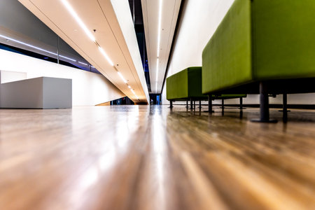 Empty green seats in the lobby inside a modern public building. Photo taken in an object lit with...