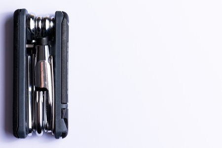 Black bicycle multifunctional multitool unfolded on a white background. Chrome steel tools. Tools for bicycle self-repairing.の写真素材