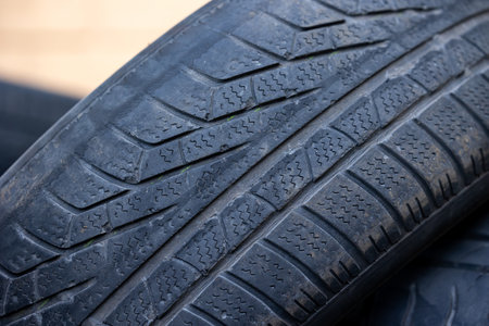 Worn and damaged tread of old tires lying in a landfill. Decreased road safety and environmental...