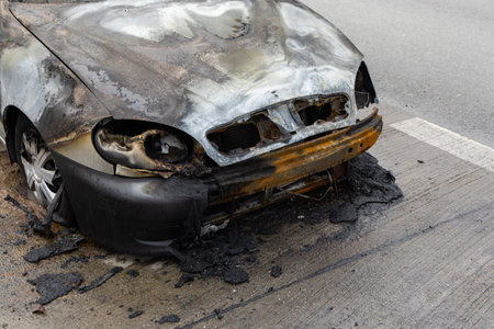 Burnt passenger car standing on the road. Vehicle with interior largely burned out.の写真素材