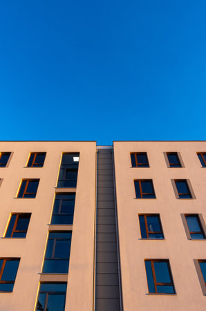 Facades of modern apartment blocks against a blue sky. Photos taken in afternoon light.