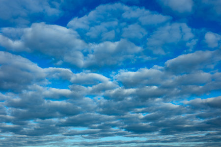 Blue sky and lot of small clouds in middle of sunny day. No horizon is visible.の写真素材