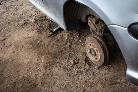 Rusty hub of an abandoned passenger car. Visible wheel arches of a gray car. Photo taken in natural lighting conditions.の写真素材