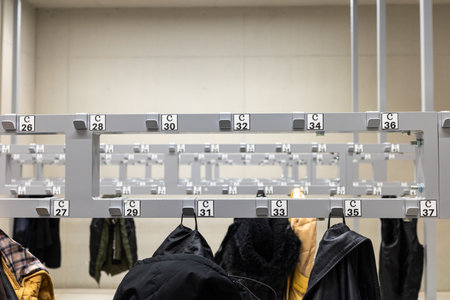 Coats and jackets hanging in the cloakroom. Photo taken in artificial light in a public utility...