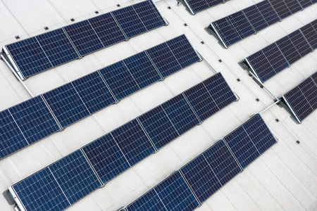 Set of solar panels on top of the concrete roof of modern building. Photovoltaic energy sources...