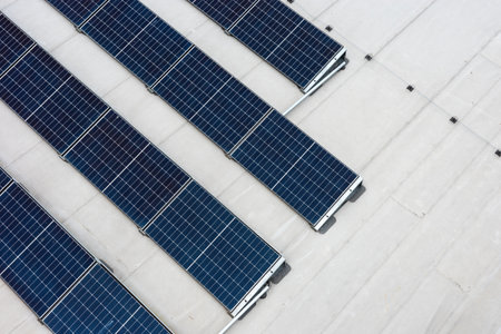 Set of solar panels on top of the concrete roof of modern building. Photovoltaic energy sources...