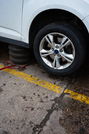A pneumatic lift holding the car in upper position. Basic tool in tire service workshop.の写真素材