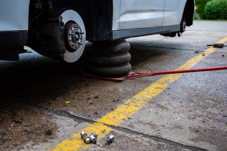 A pneumatic lift holding the car in upper position. Basic tool in tire service workshop.の写真素材