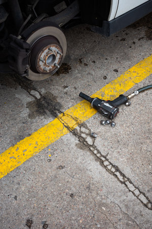 A pneumatic wrench used to change a flat tire on a passenger car. The hub and brake discs are...
