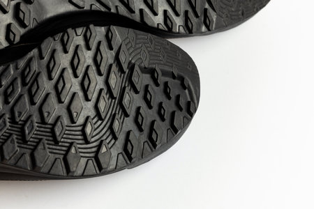 Hiking boot soles on a white background. Details of the grippy tread are clearly visible. Photo...