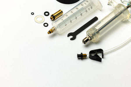 Hydraulic bicycle brake bleeding and oil change kit. Hydraulic brake service tools on a white...