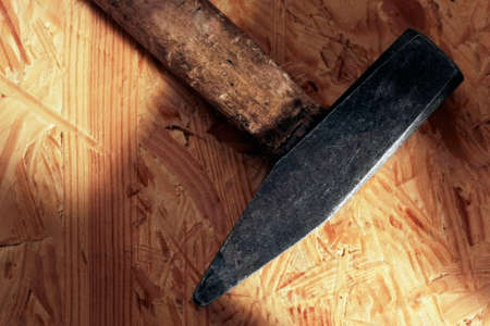 old used hammer on structured wooden boardの写真素材