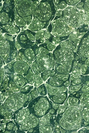 Light and dark stained green abstract pattern like a vintage retro paperback as a grunge background imageの写真素材
